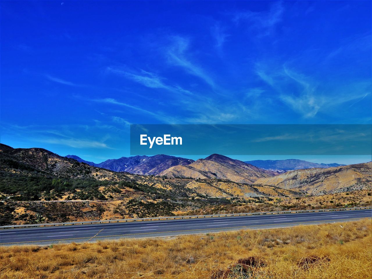 Scenic view of landscape and mountains against blue sky