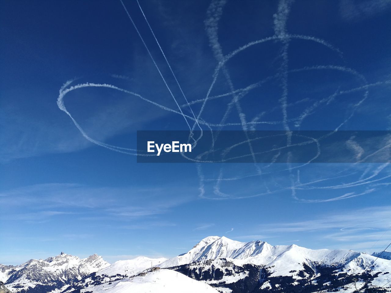 Low angle view of vapor trail against sky during winter