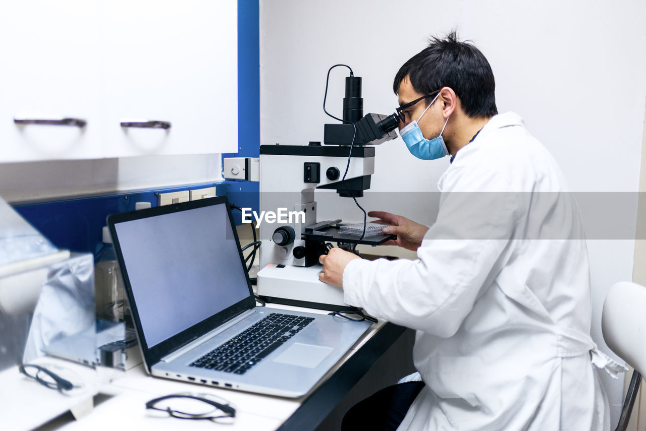 Male scientist using microscopy in laboratory