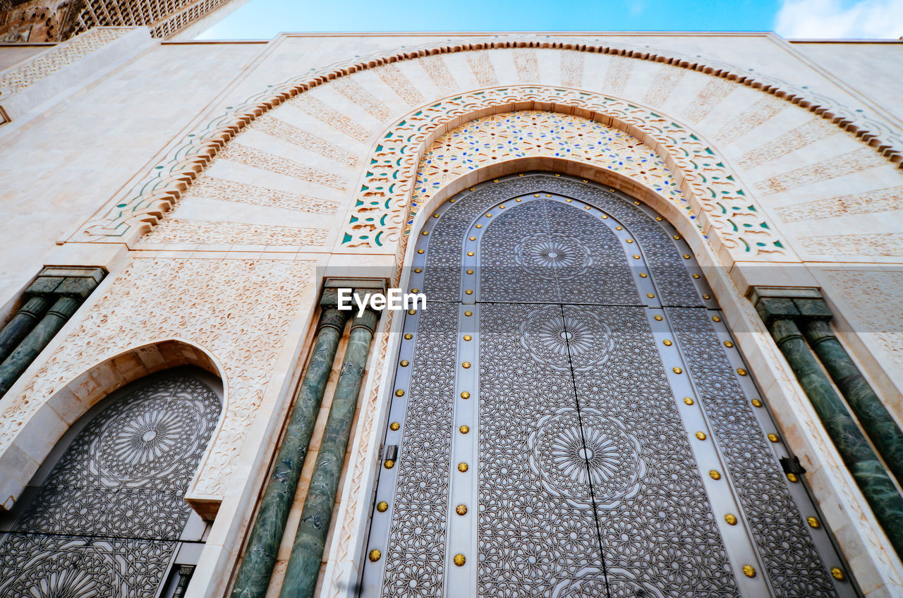 Low angle view of mosque hassan ii against sky in city