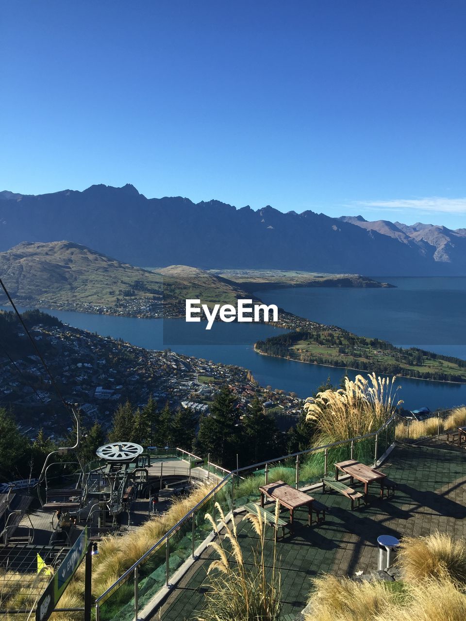 Scenic view of lake and mountains against clear blue sky