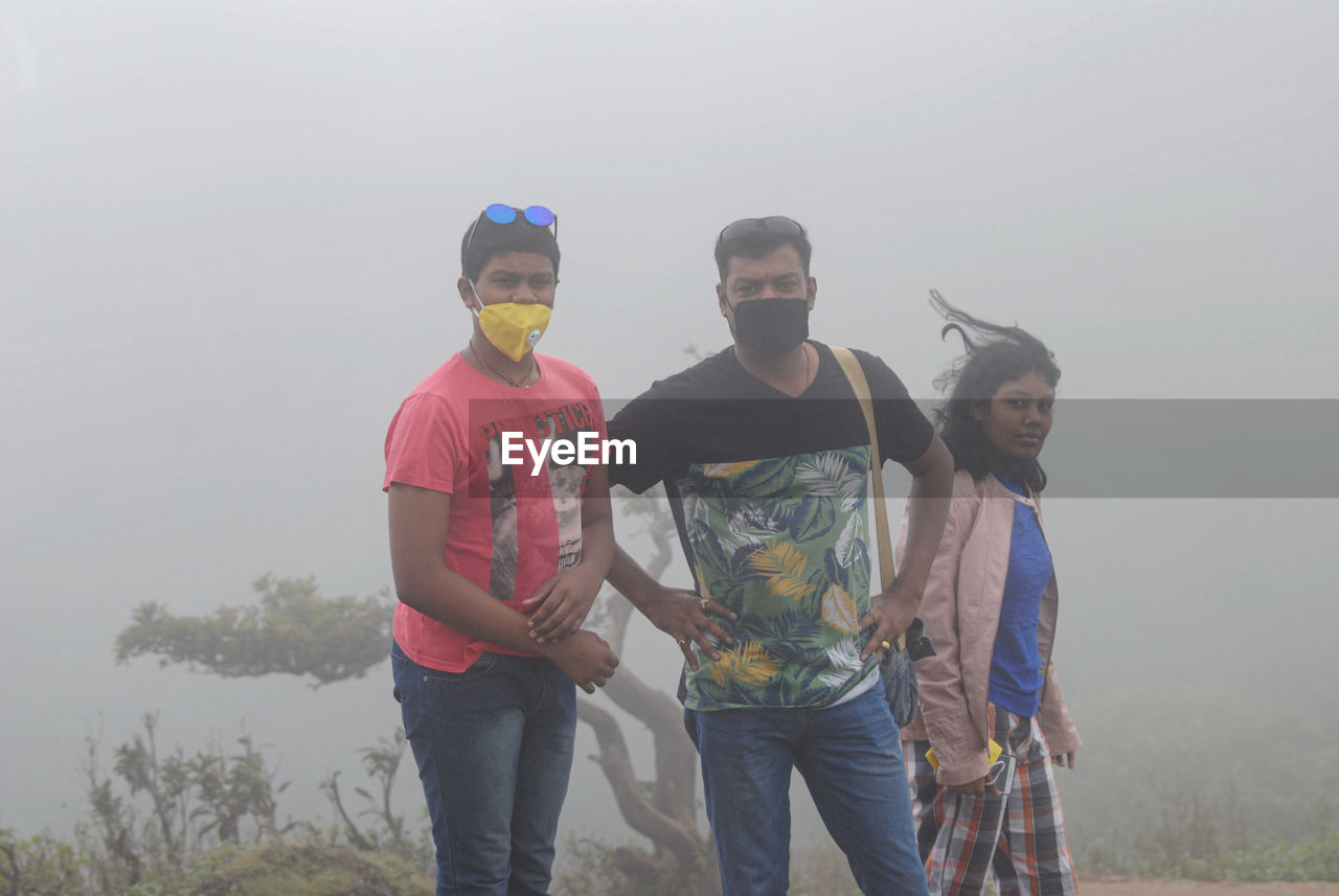 Three people wearing masks