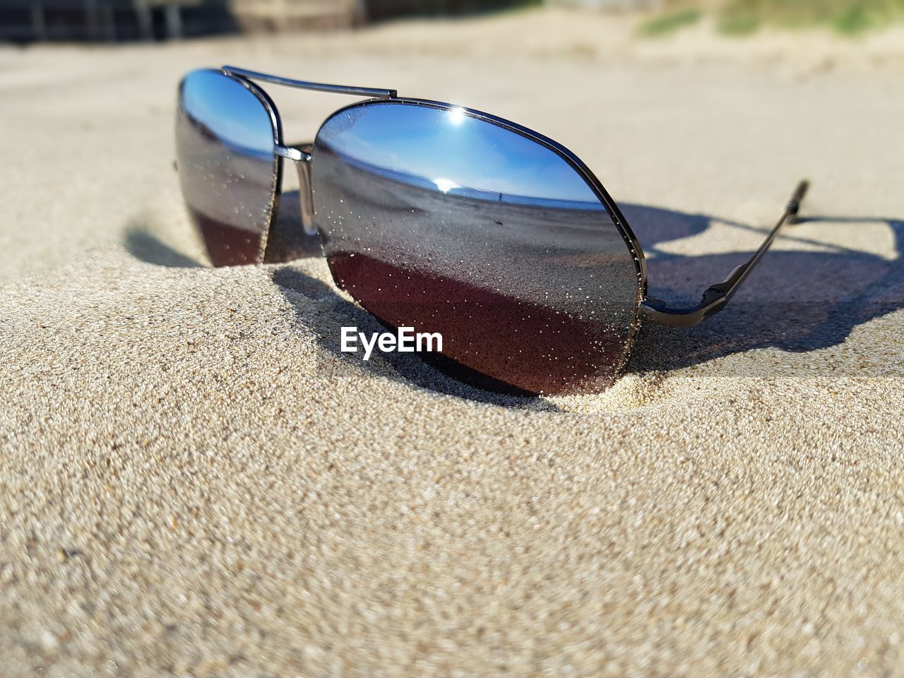 Close-up of sunglasses on sand