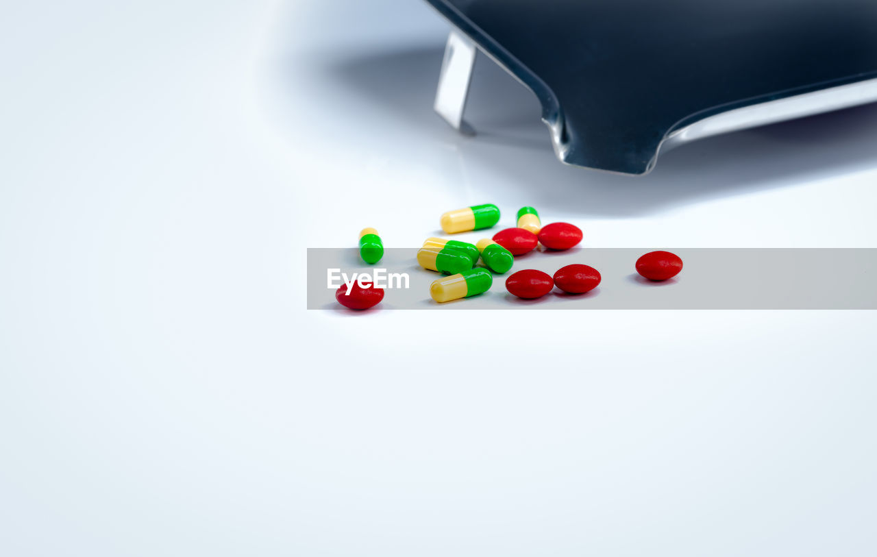 CLOSE-UP OF MULTI COLORED CANDIES ON WHITE BACKGROUND