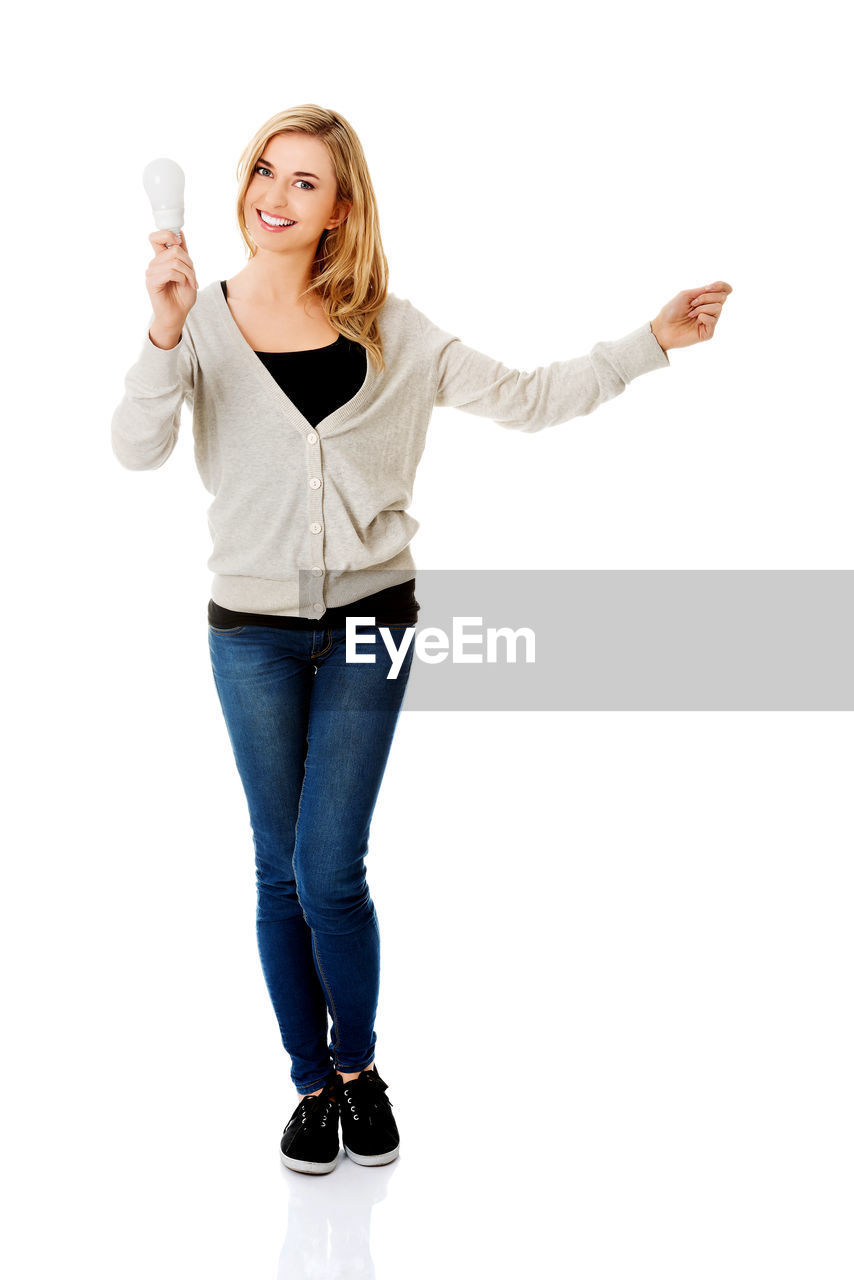 Woman holding equipment during pregnancy test against white background