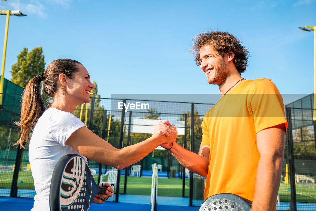 Smiling athletes shaking hands outdoors