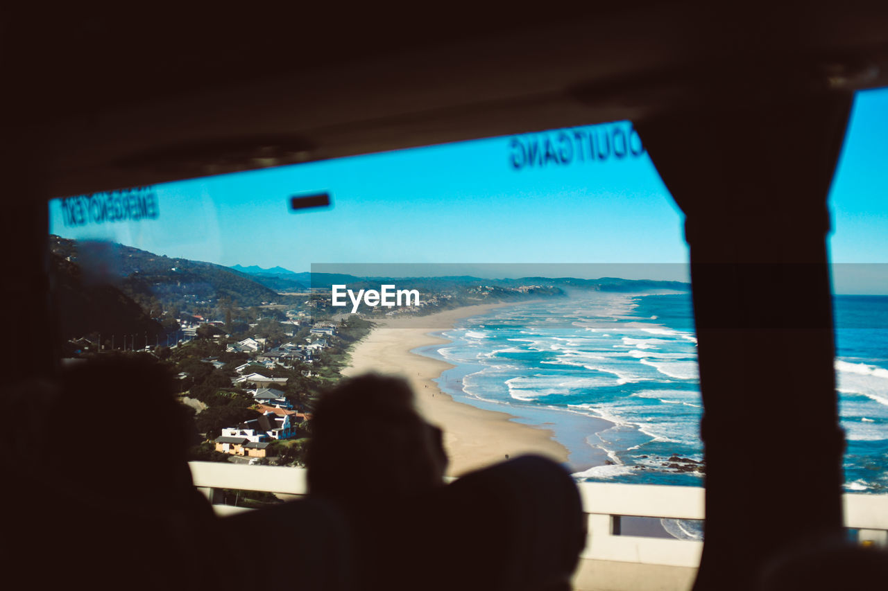 Scenic view of beach seen through window