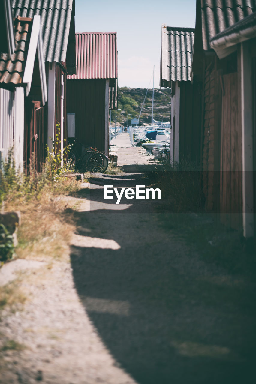 EMPTY ALLEY AMIDST HOUSES AND BUILDINGS