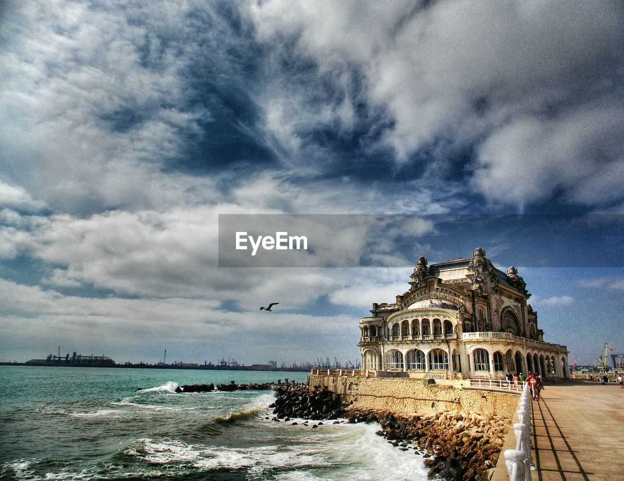 VIEW OF HARBOR AGAINST CLOUDY SKY