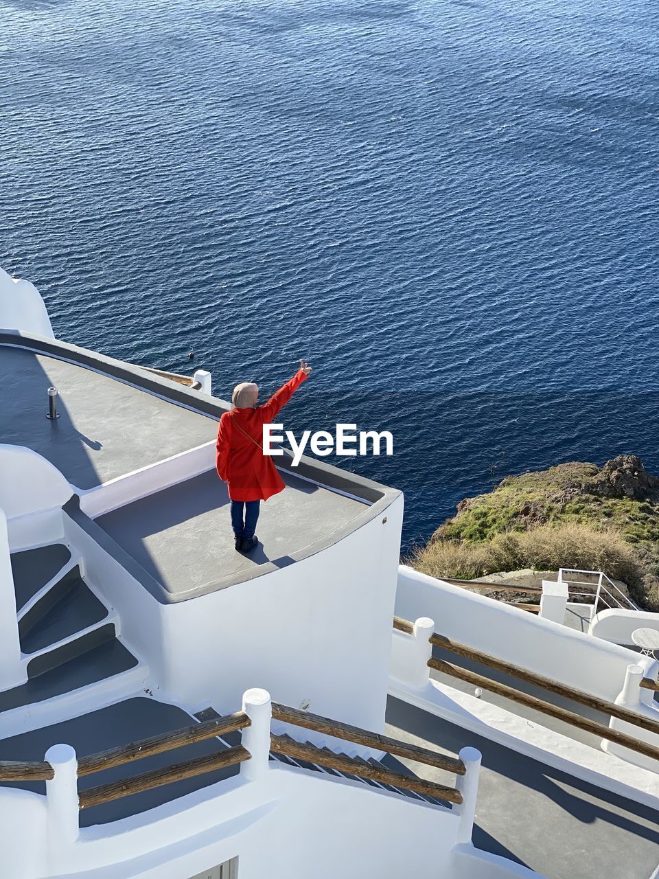 High angle view of man standing beside the sea in santorini