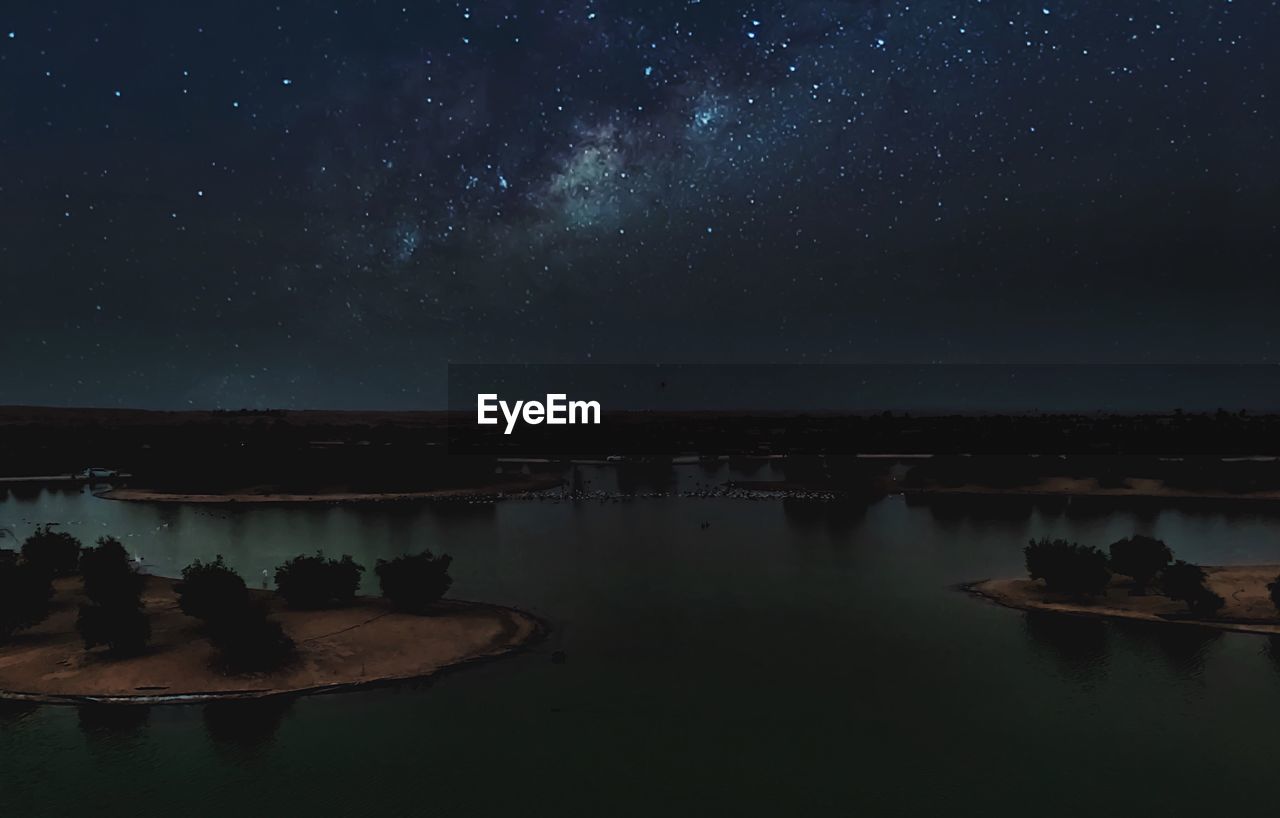 Scenic view of lake against sky at night