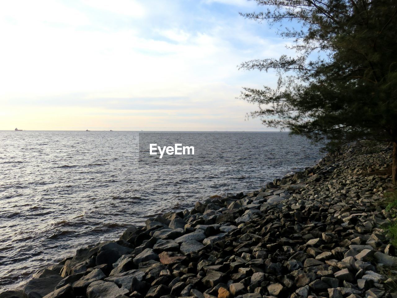 SCENIC VIEW OF SEA BY ROCKS AGAINST SKY