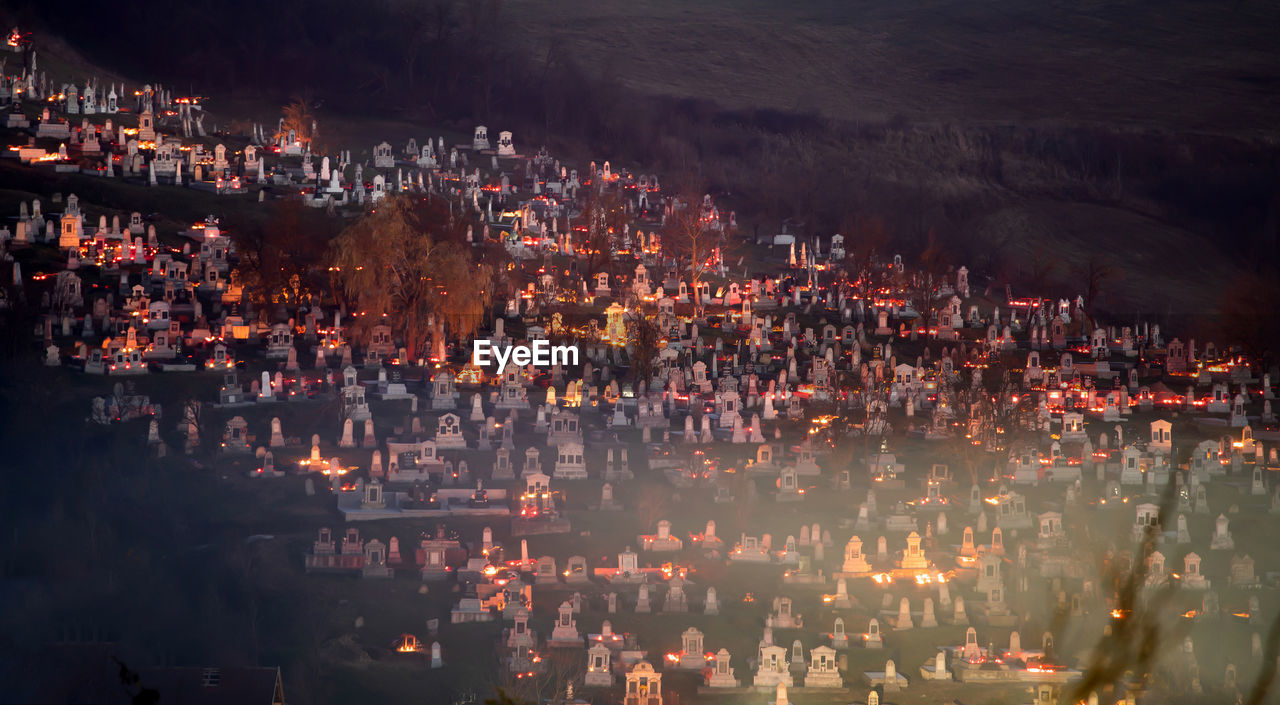 HIGH ANGLE VIEW OF ILLUMINATED BUILDINGS IN CITY