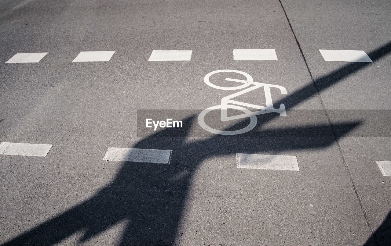 High angle view of bicycle lane sign on road during sunny day
