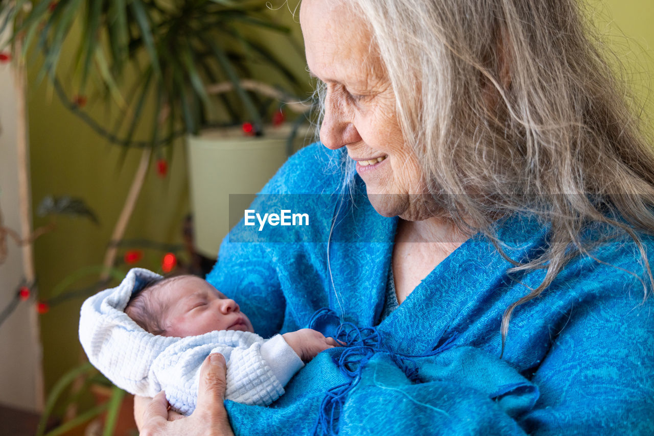 Midsection of grandmother holding granddaughter