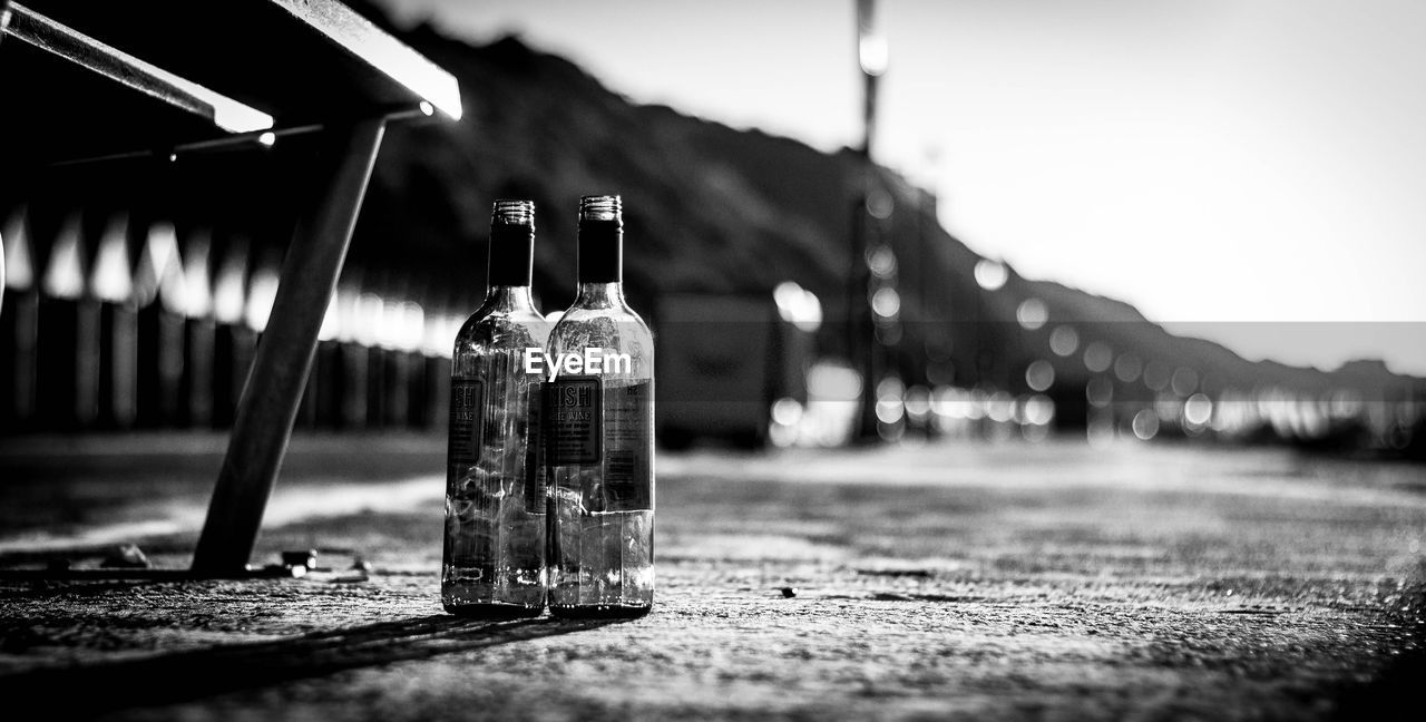 CLOSE-UP OF GLASS BOTTLES ON TABLE