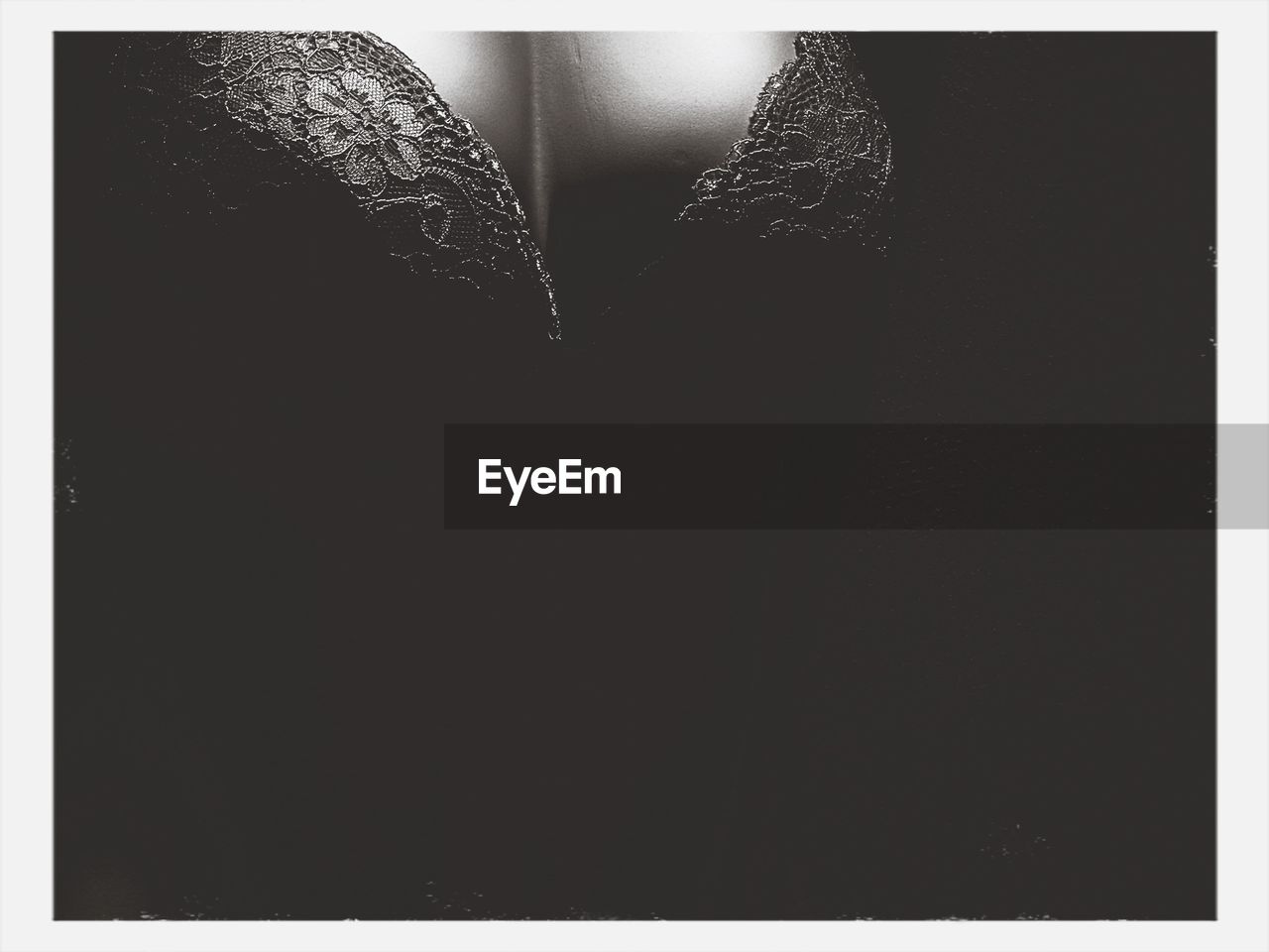 Midsection of sensuous woman against black background