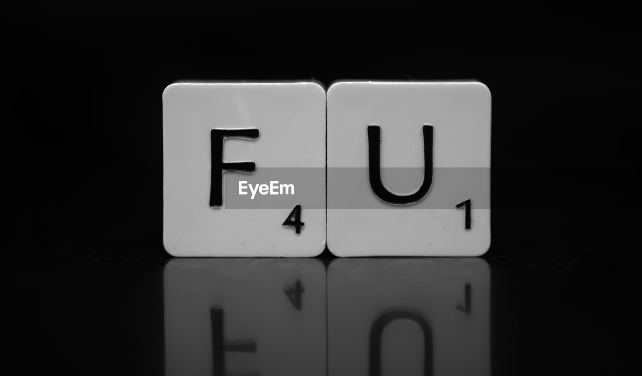 Close-up of scrabble tiles on table with reflection