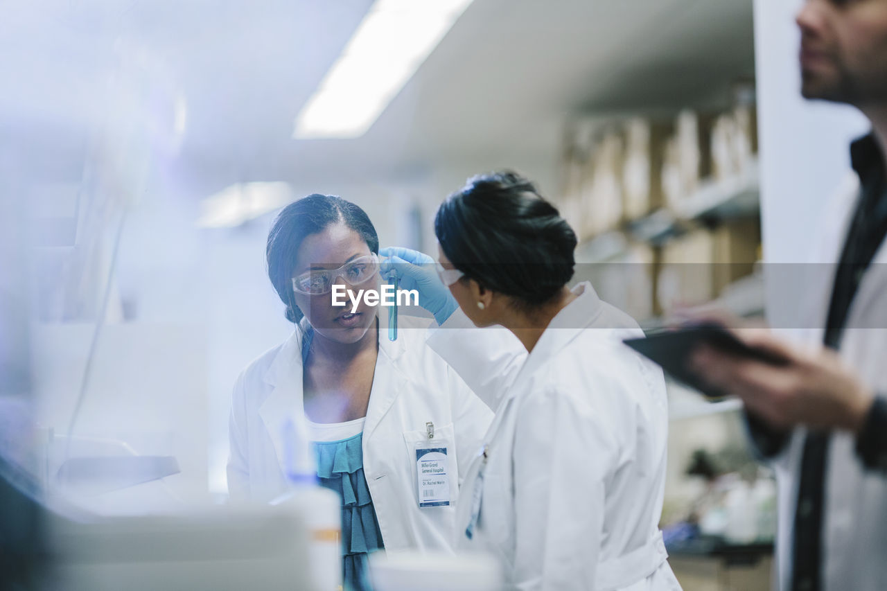 Female doctors examining test tubes in laboratory