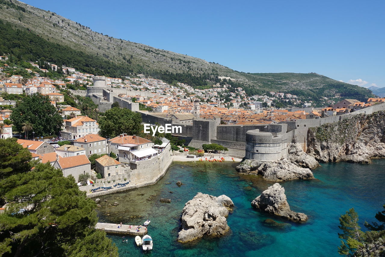 high angle view of townscape by sea against clear sky