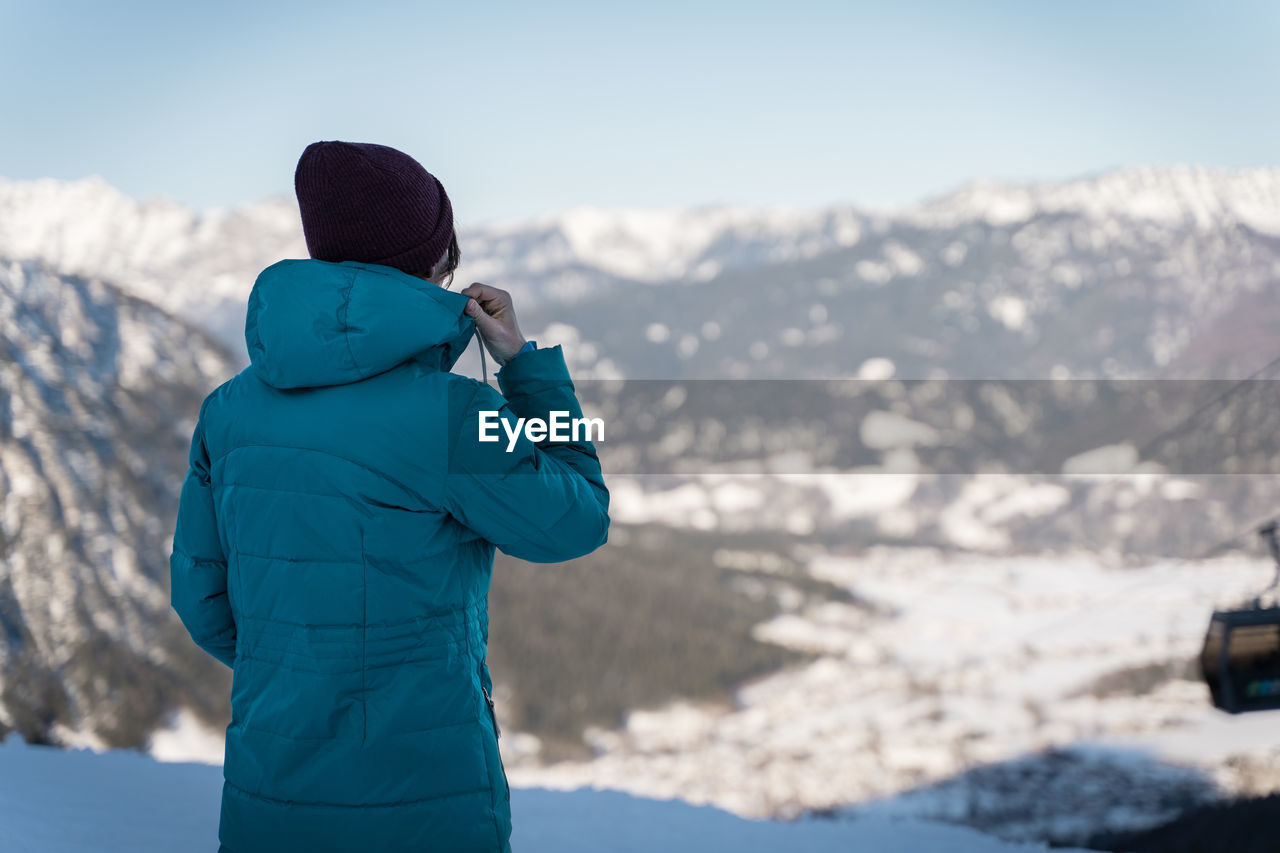 Rear view of woman looking at snowcapped mountain