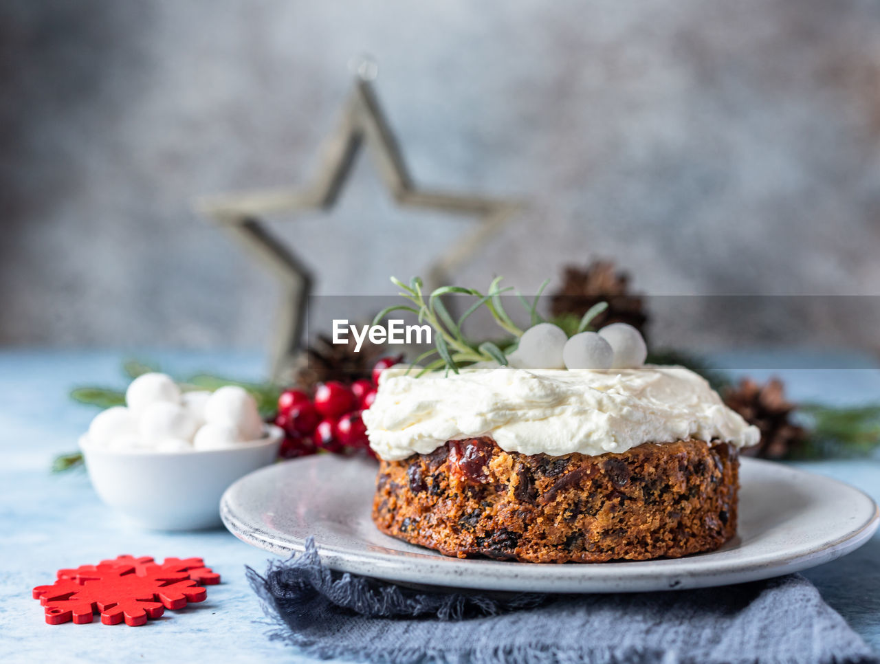 Christmas fruit cake or pudding with glaze, rosemary and cranberries. traditional winter bakery.