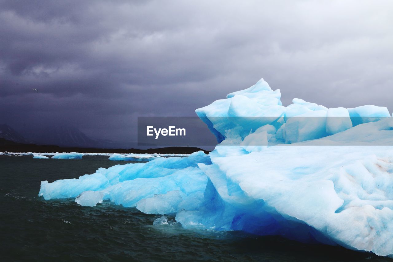 Ice floating on sea against sky during winter