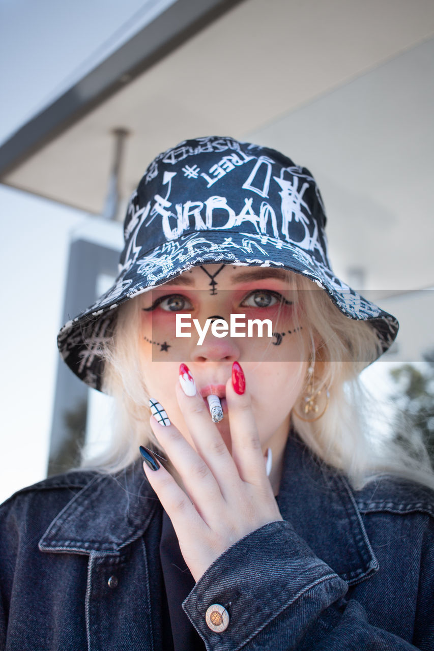 Portrait of beautiful young woman smoking cigarette