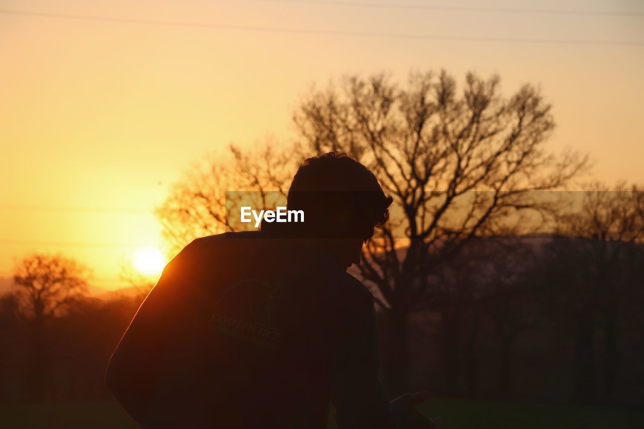 Silhouette woman standing against sky during sunset