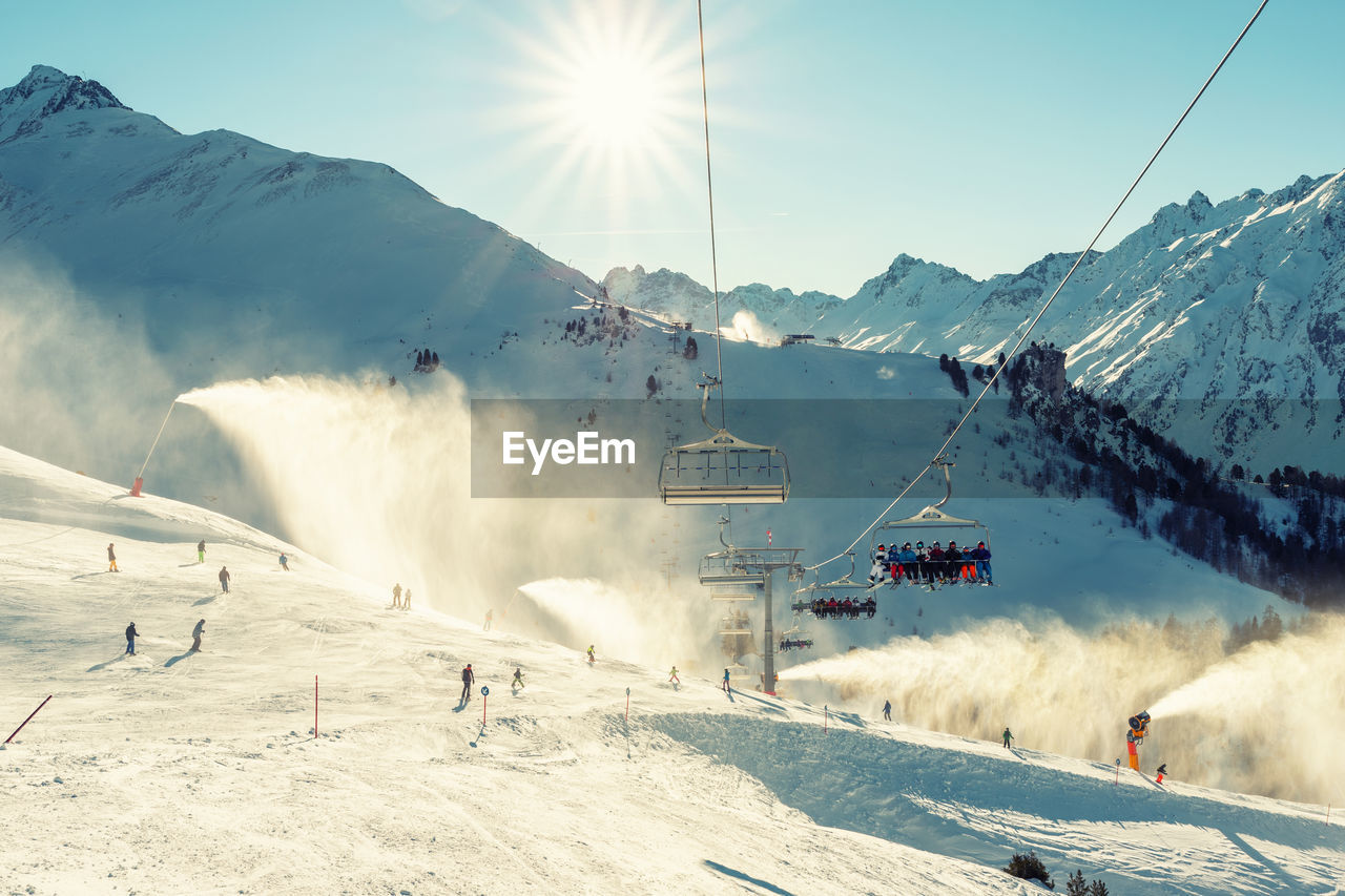 PANORAMIC VIEW OF SKI LIFT AGAINST SNOWCAPPED MOUNTAIN