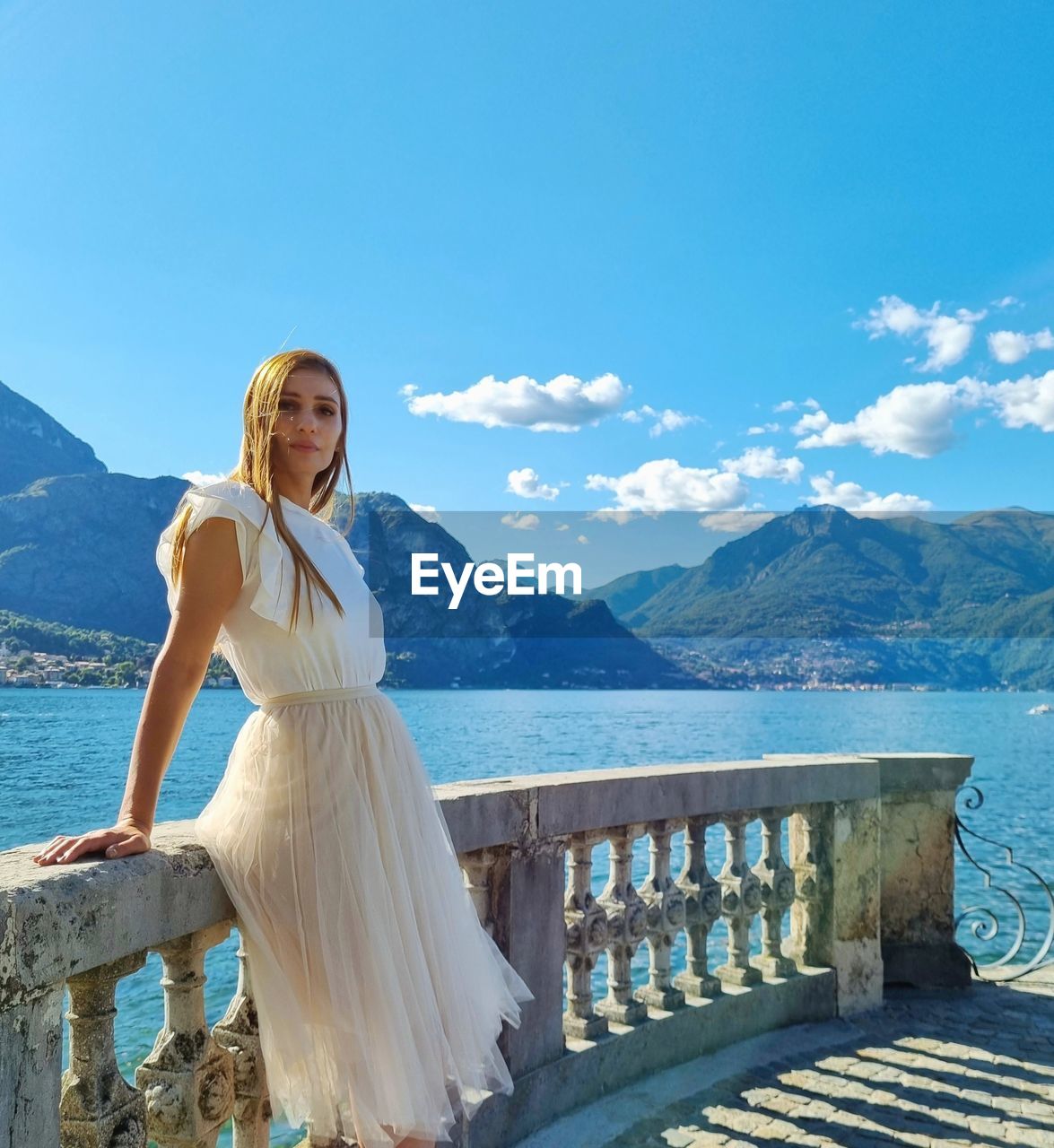 Woman with arms raised against mountains and sky