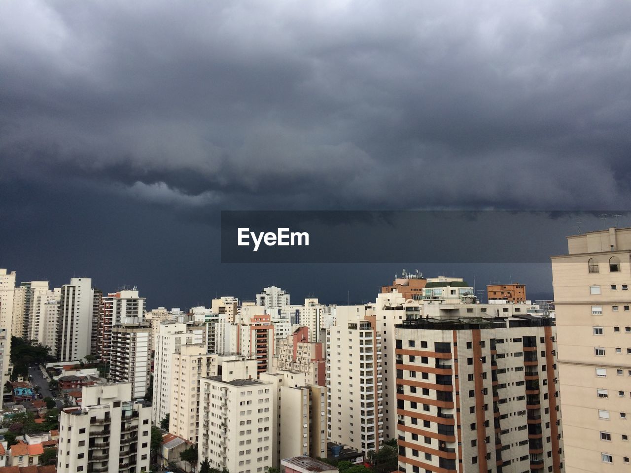 View of cityscape against cloudy sky