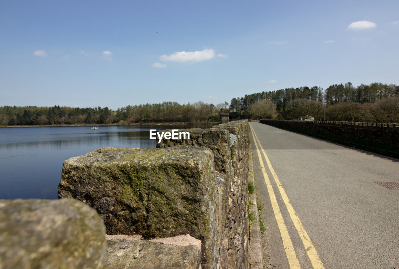 Road by lake against sky
