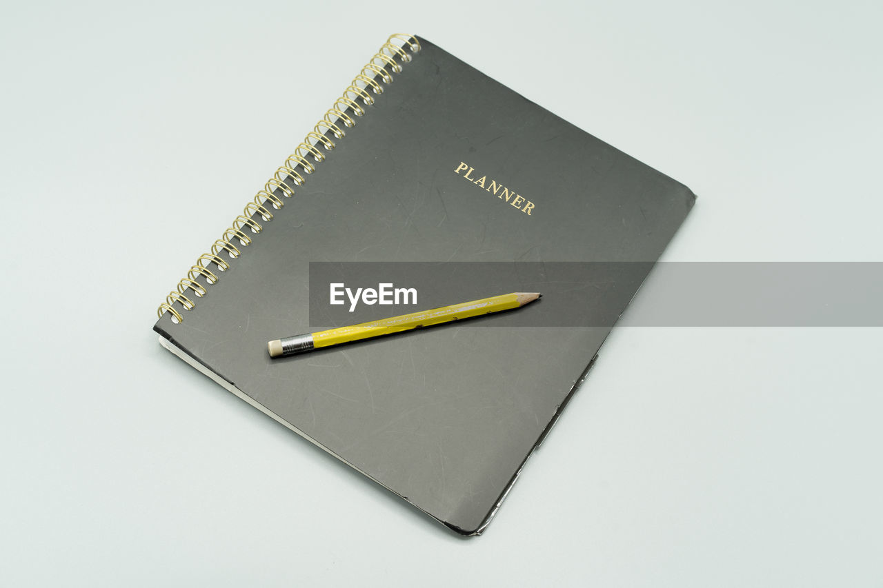 HIGH ANGLE VIEW OF PENCIL ON BOOK