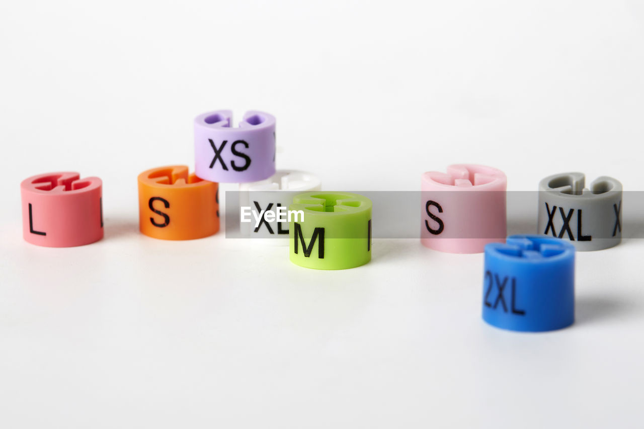 Close-up of alphabets on multi colored beads over white background