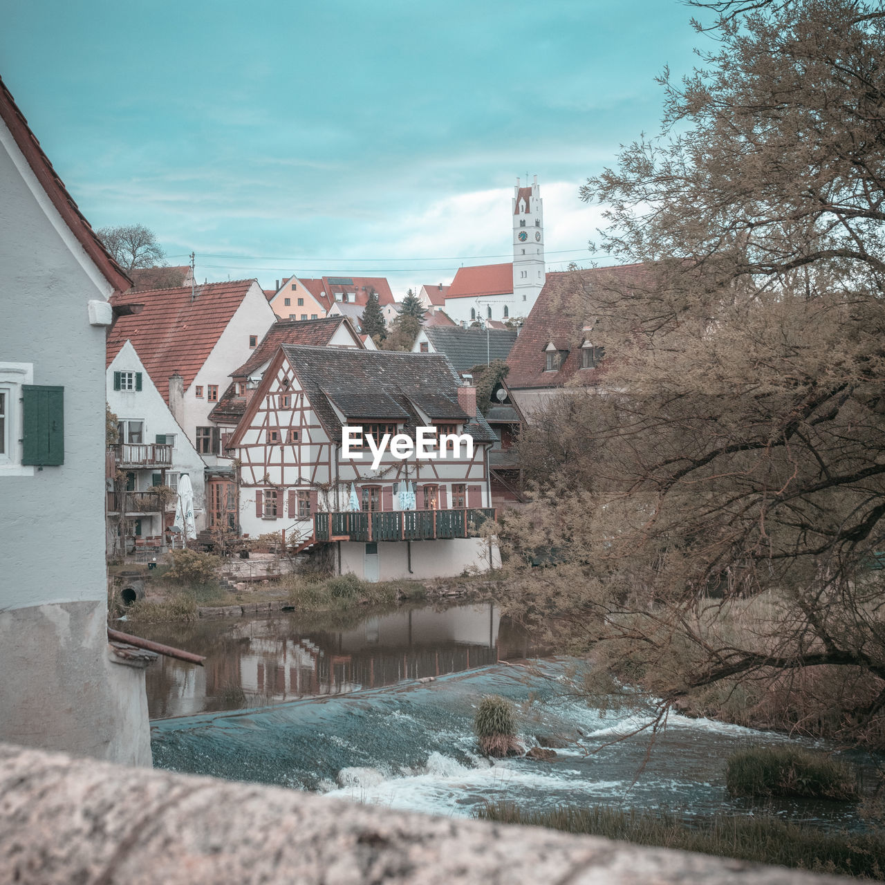 HOUSES BY RIVER AGAINST SKY