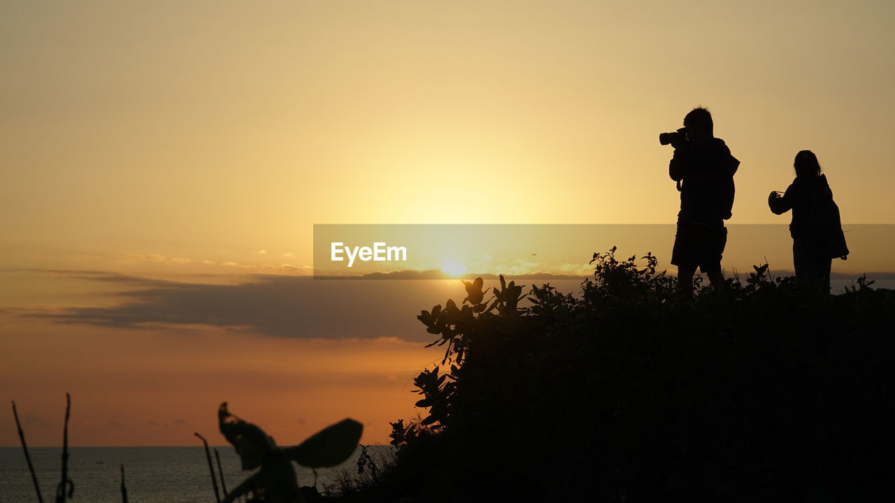 SILHOUETTE PEOPLE AGAINST SUNSET SKY