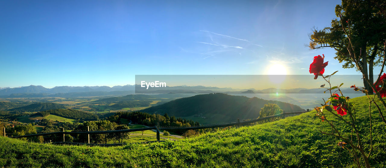 SCENIC VIEW OF FIELD AGAINST MOUNTAINS AGAINST SKY