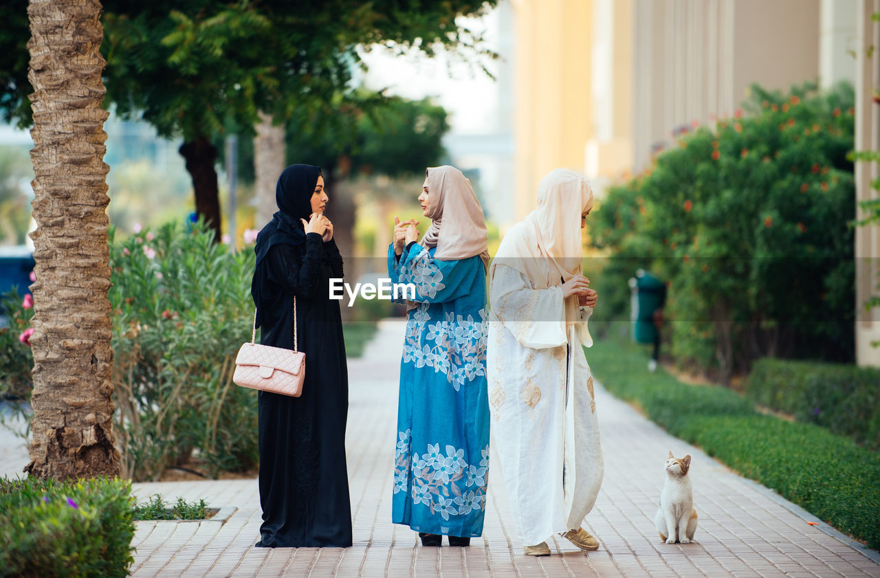 Full length of women wearing hijab standing on footpath