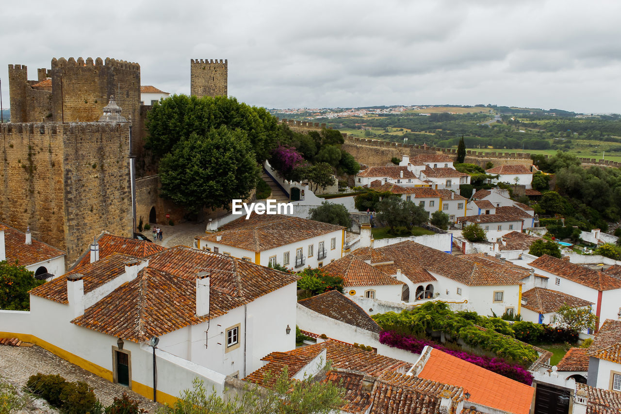 High angle view of houses in medieval town of obidos with castle against sky