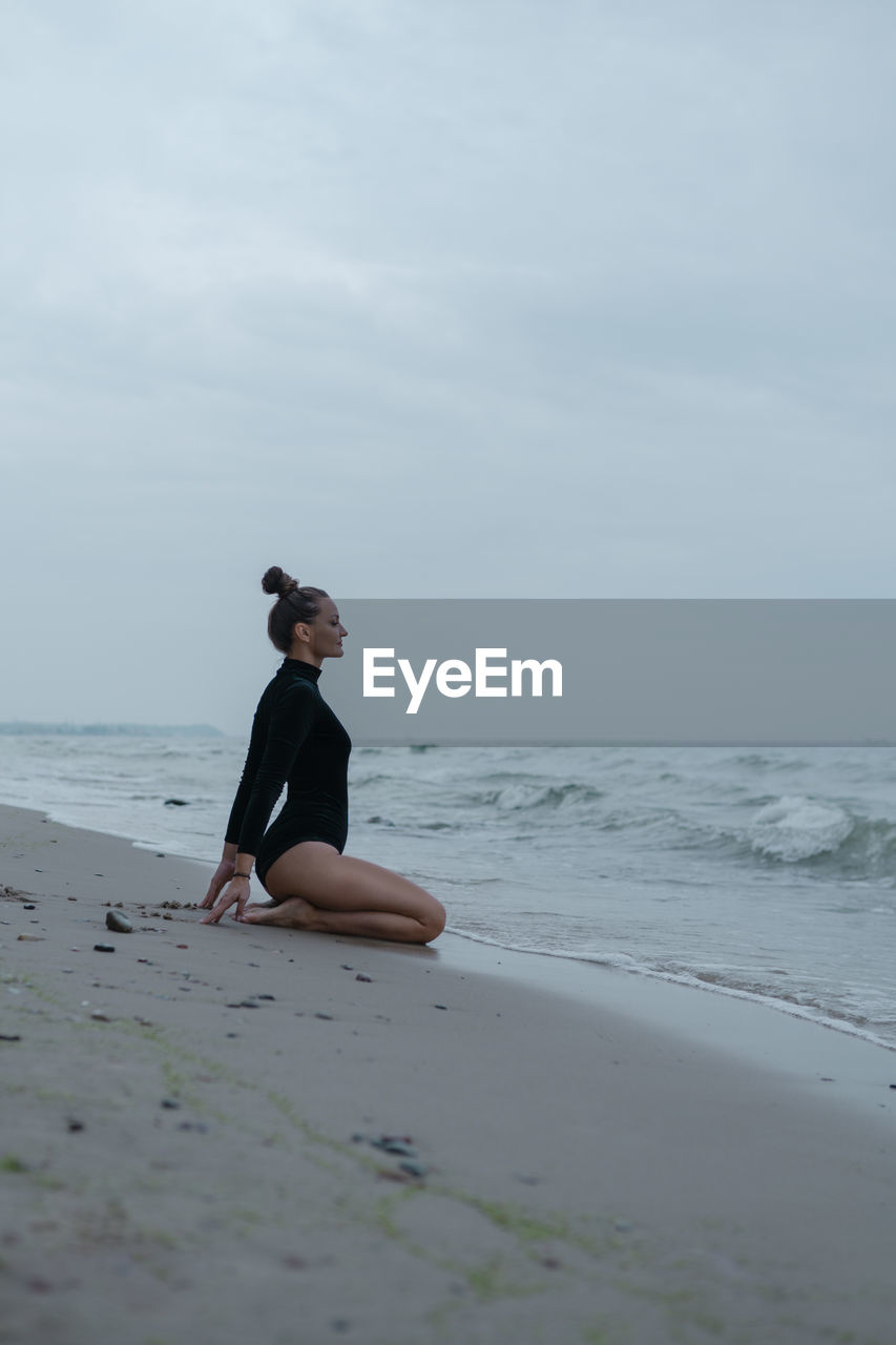 Full length of woman on beach against sky