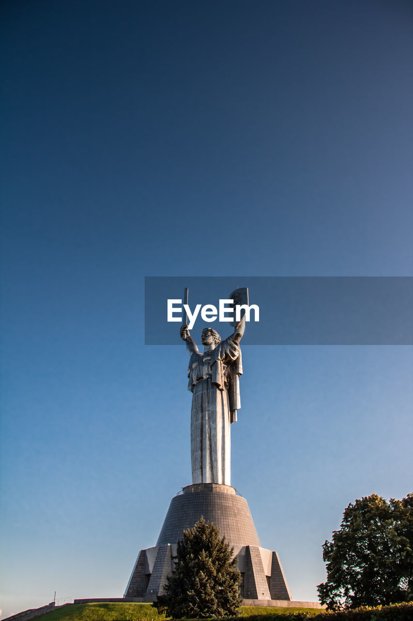 Low angle view of statue against clear blue sky