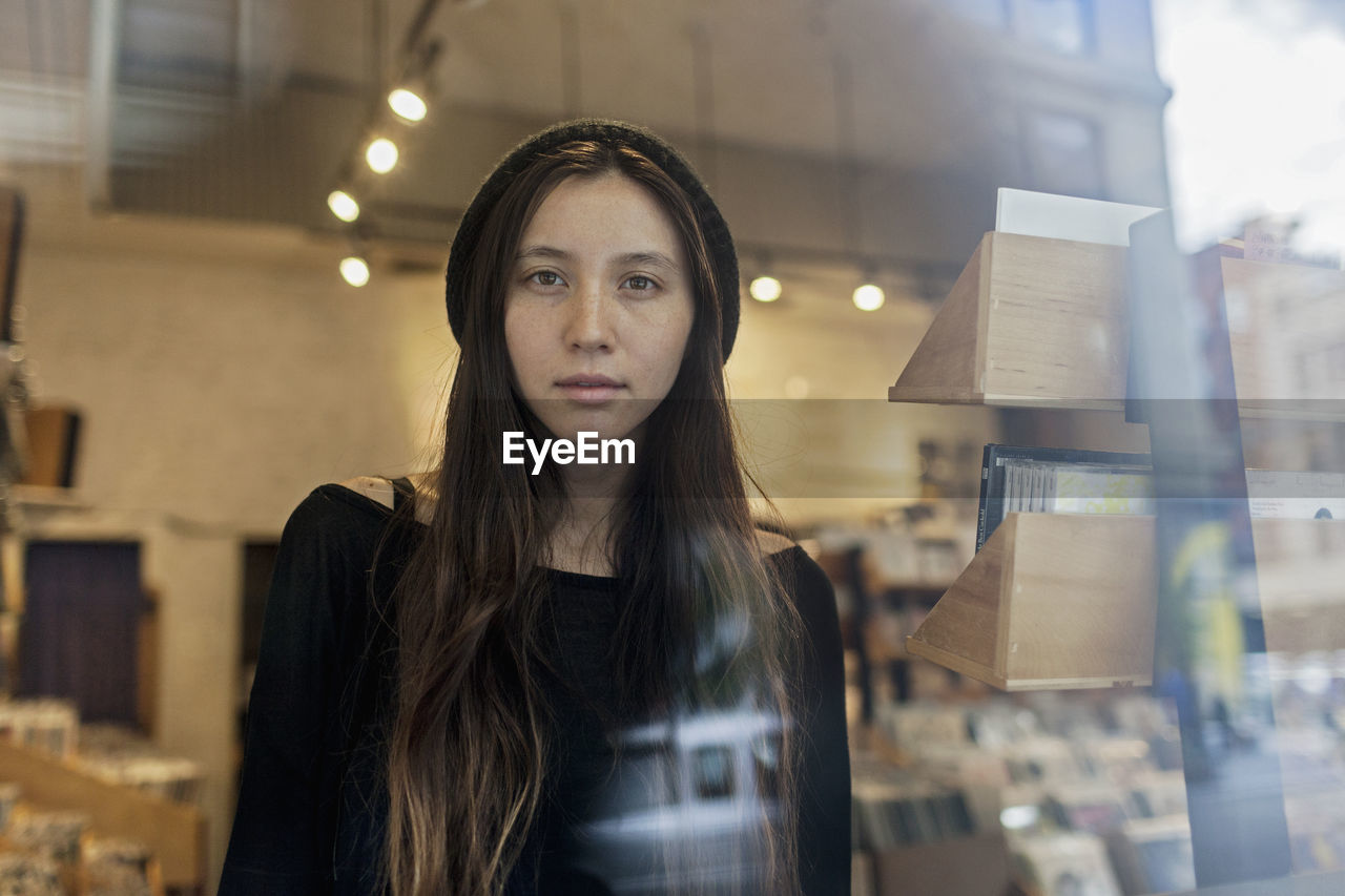 Portrait of a young woman through a window