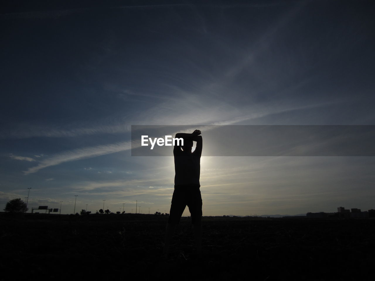 Silhouette man standing on field against sky