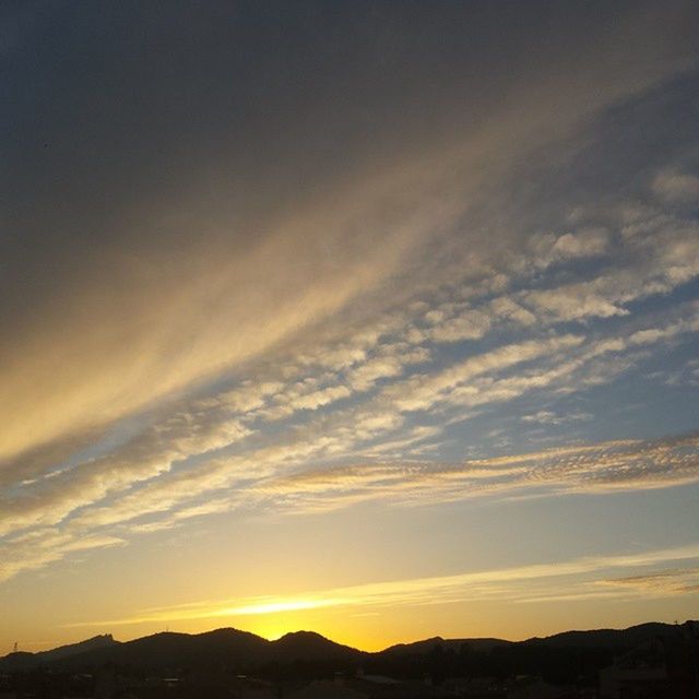 SCENIC VIEW OF MOUNTAINS AT SUNSET