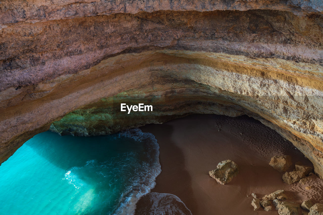 Benagil wild hidden secret cave beach top view above with turquoise water in carvoeiro, portugal