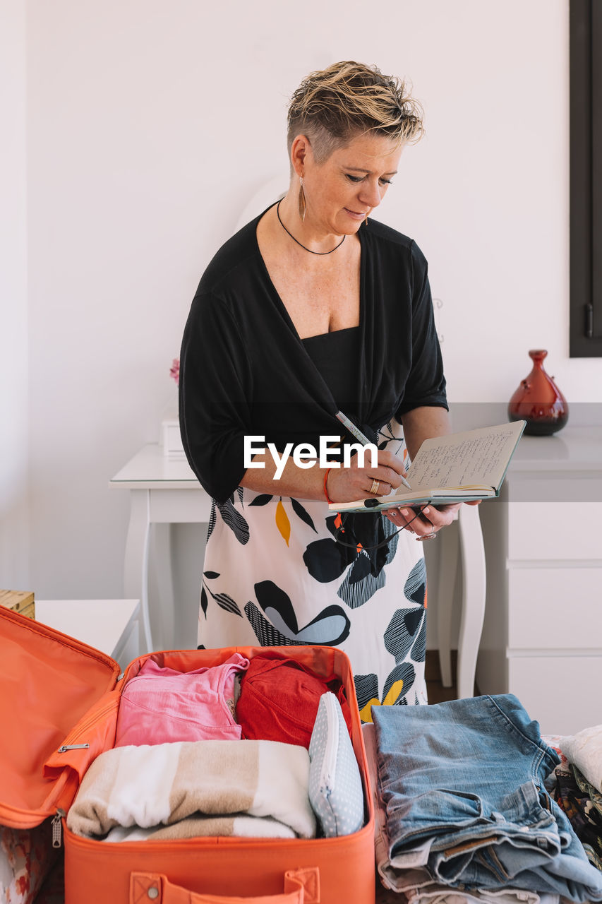 portrait of young woman using digital tablet while sitting on sofa at home