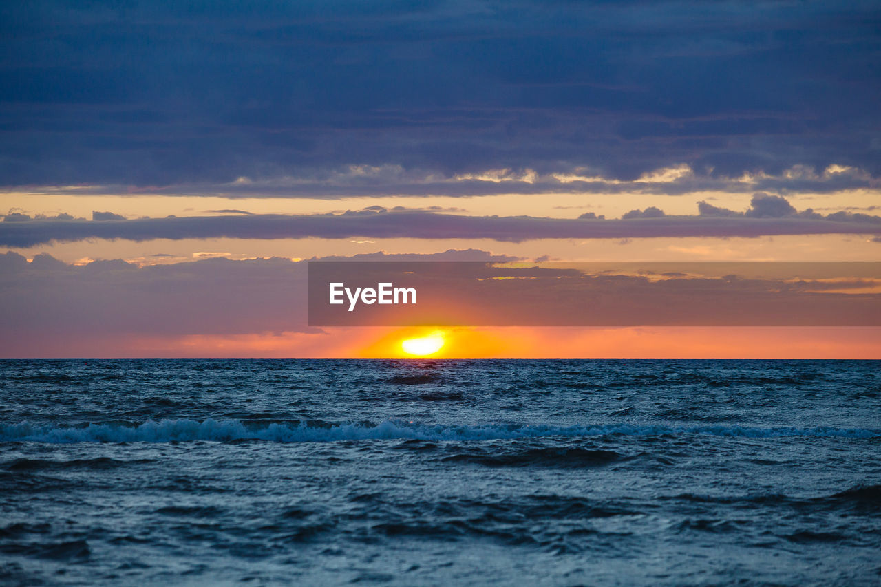 SCENIC VIEW OF SEA AGAINST SKY AT SUNSET