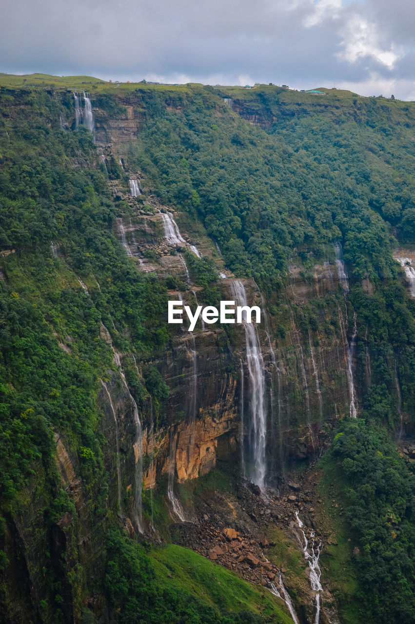 SCENIC VIEW OF WATERFALL ON MOUNTAIN