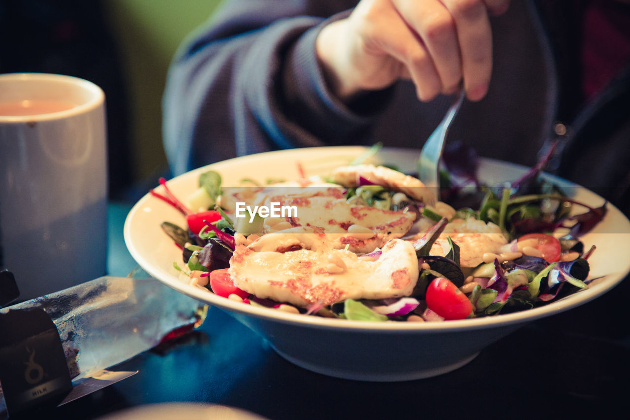 Close-up of person eating food served on table